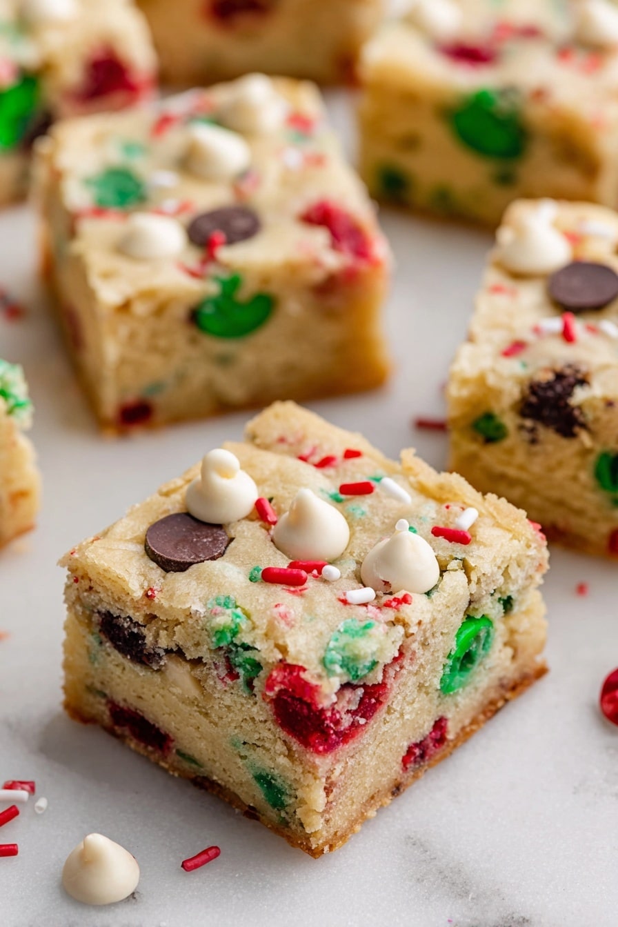 Christmas Cookie Bars, Festive Cookie Bars, Holiday Cookie Bars, Easy Christmas Cookies, Christmas Dessert Ideas - The image shows square pieces of soft, light-colored cookie bars spread out on a white marbled surface. Each bar has two layers: a thick, slightly crumbly beige cookie base studded with colorful red and green candy pieces, along with dark and white chocolate chips scattered evenly throughout. The top layer is the same cookie dough with visible embedded candy and chips, giving a festive look. Small white and red sprinkles are also scattered on the surface of the bars. Photo taken with an iphone --ar 2:3 --v 7