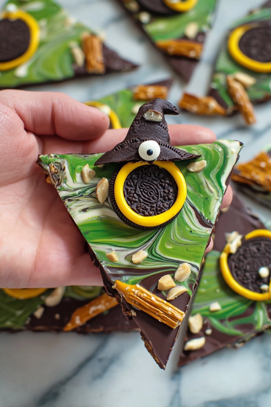 Melted Witch Halloween Bark, Halloween candy bark, spooky Halloween treats, witch-themed Halloween dessert, easy Halloween party snacks - The image shows a hand holding a triangular piece of chocolate bark with three visible layers. The bottom layer is solid dark chocolate with a smooth finish. The middle layer is a swirl of green and white chocolate, creating a marbled effect. On top, there is a decorated Oreo cookie with a small chocolate witch hat in the center, outlined with a bright yellow ring of icing. Around the bark, there are small white candy eyes and slivers of white nuts scattered. The piece is finished with pretzel sticks dipped in chocolate placed diagonally at the edges, creating a broomstick look. The background is a white marbled surface with more similar chocolate bark pieces nearby. Photo taken with an iphone --ar 2:3 --v 7