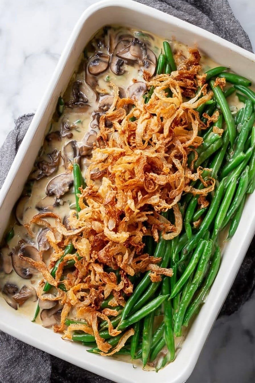 Creamy Mushroom Green Bean Casserole with Crispy Baked Onions, green bean casserole with mushroom sauce, baked onion casserole, holiday green bean side dish, easy mushroom green bean bake - A white square tray filled with a single thin layer of crispy fried onion strings, showing a mix of pale golden and light brown colors, some pieces are curled and others are straight, with slight dark brown edges indicating toasted spots. The texture looks crunchy and scattered unevenly across the tray, resting on a white marbled surface. Photo taken with an iphone --ar 2:3 --v 7
