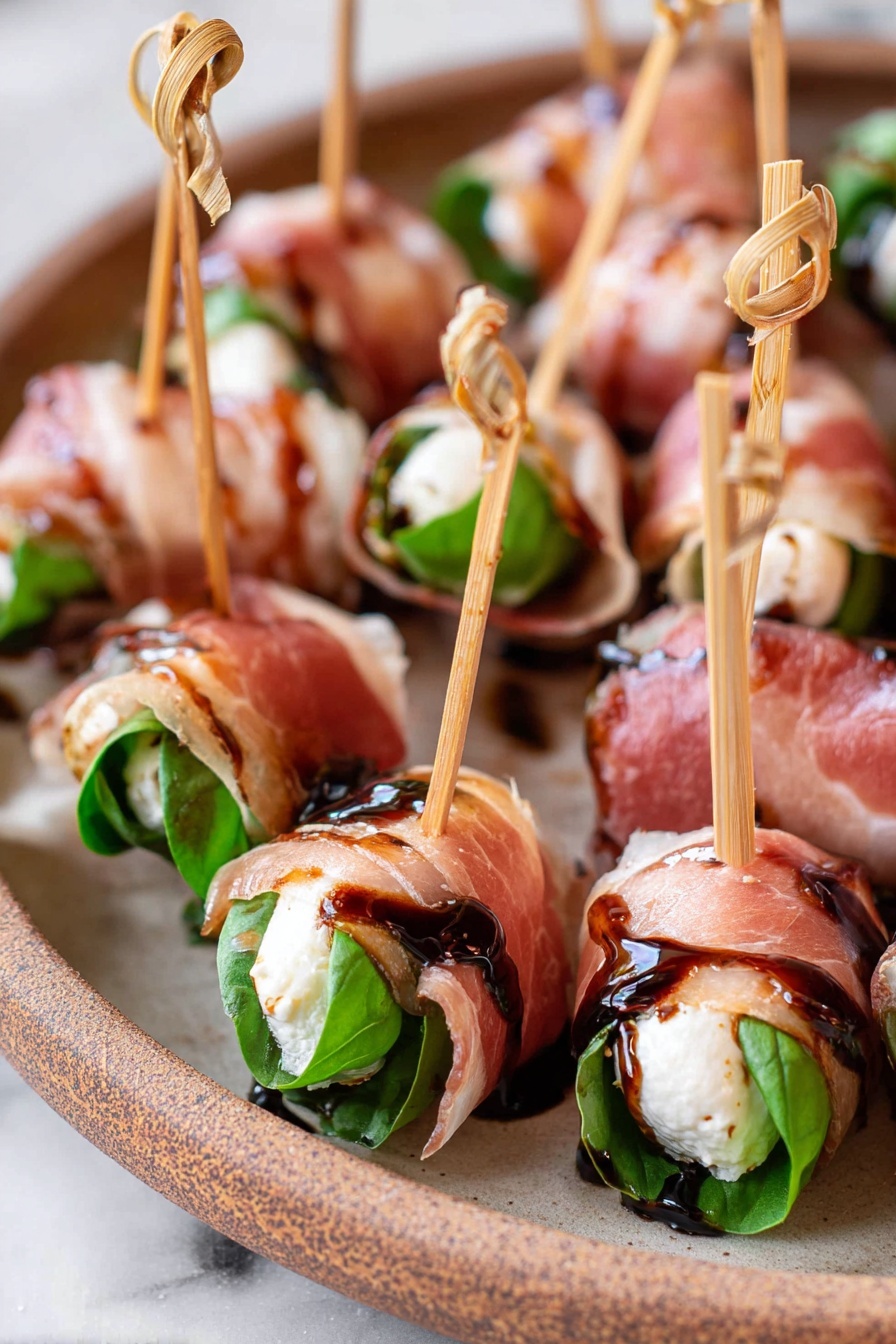 Prosciutto Mozzarella Bites Basil, prosciutto appetizer with basil, easy prosciutto mozzarella snacks, Caprese-inspired appetizer, quick prosciutto bites - The image shows many small rolls arranged closely on a beige plate with a rustic look, all placed on a white marbled surface. Each roll has three visible layers: a dark green fresh basil leaf inside, a white creamy cheese layer wrapped around the leaf, and a thin, translucent pink cured meat layer folded around the outside. Each roll is pierced with a light brown wooden skewer with a small knot at the top, and a glossy dark brown balsamic glaze is lightly drizzled on top, adding a shiny, sticky texture. Photo taken with an iphone --ar 2:3 --v 7