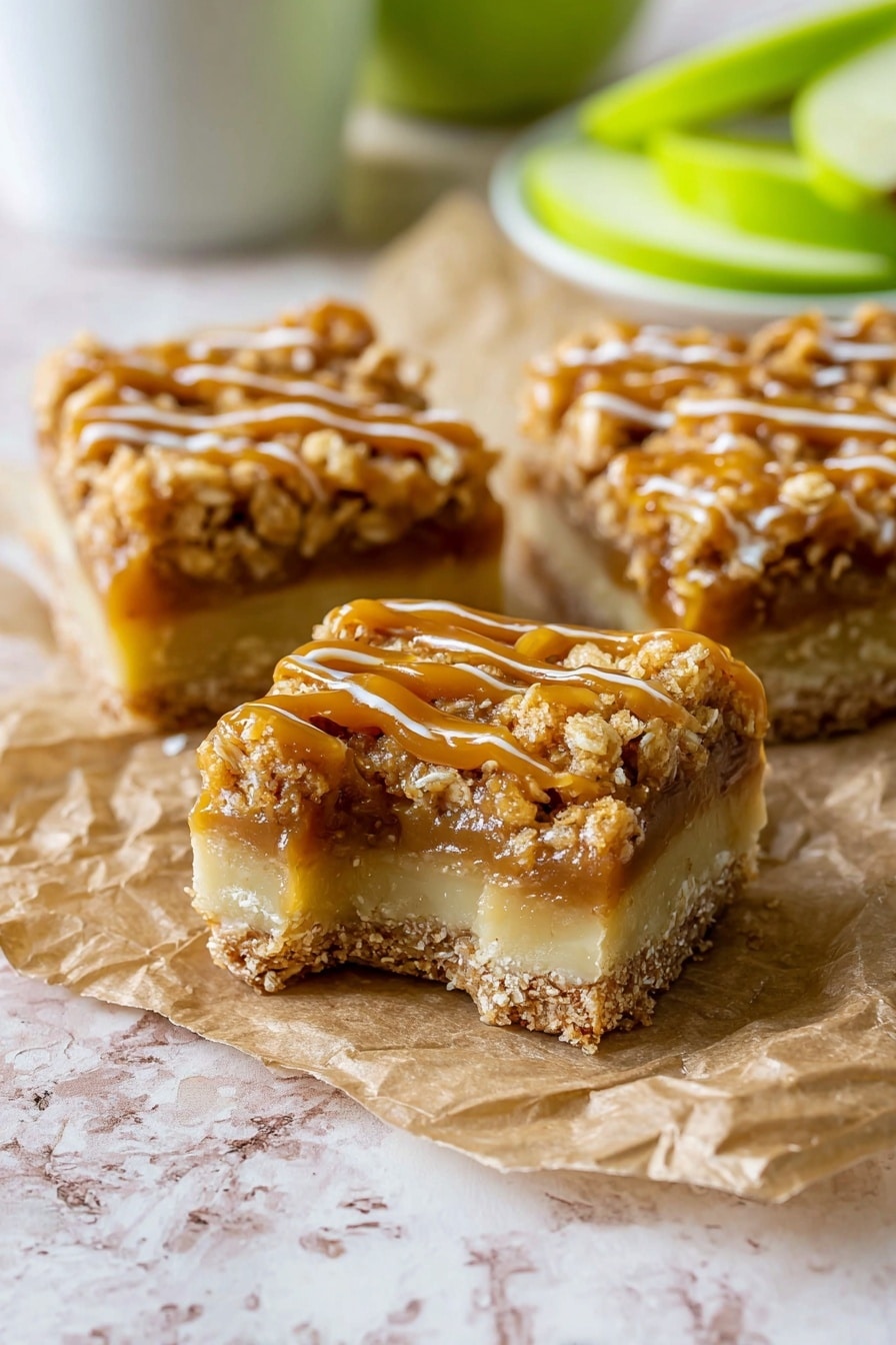 Salted Caramel Apple Pie Bars, Apple Pie Bars with Salted Caramel, Fall Apple Dessert Bars, Easy Apple Pie Bars, Caramel Apple Bars - The image shows three square pieces of dessert bars on a crumpled piece of brown parchment paper resting on a white marbled surface. Each bar has three clear layers: a pale beige bottom layer that looks firm and smooth, a middle layer of light caramel filling, and a thick crumbly top layer coated with a shiny golden caramel drizzle. The crumbly top is textured with small oat pieces, giving a crunchy look. The bars are close together, with one piece having a bite taken out, showing the inside texture clearly. In the background, blurred green apple slices and a white cup are visible. Photo taken with an iphone --ar 2:3 --v 7