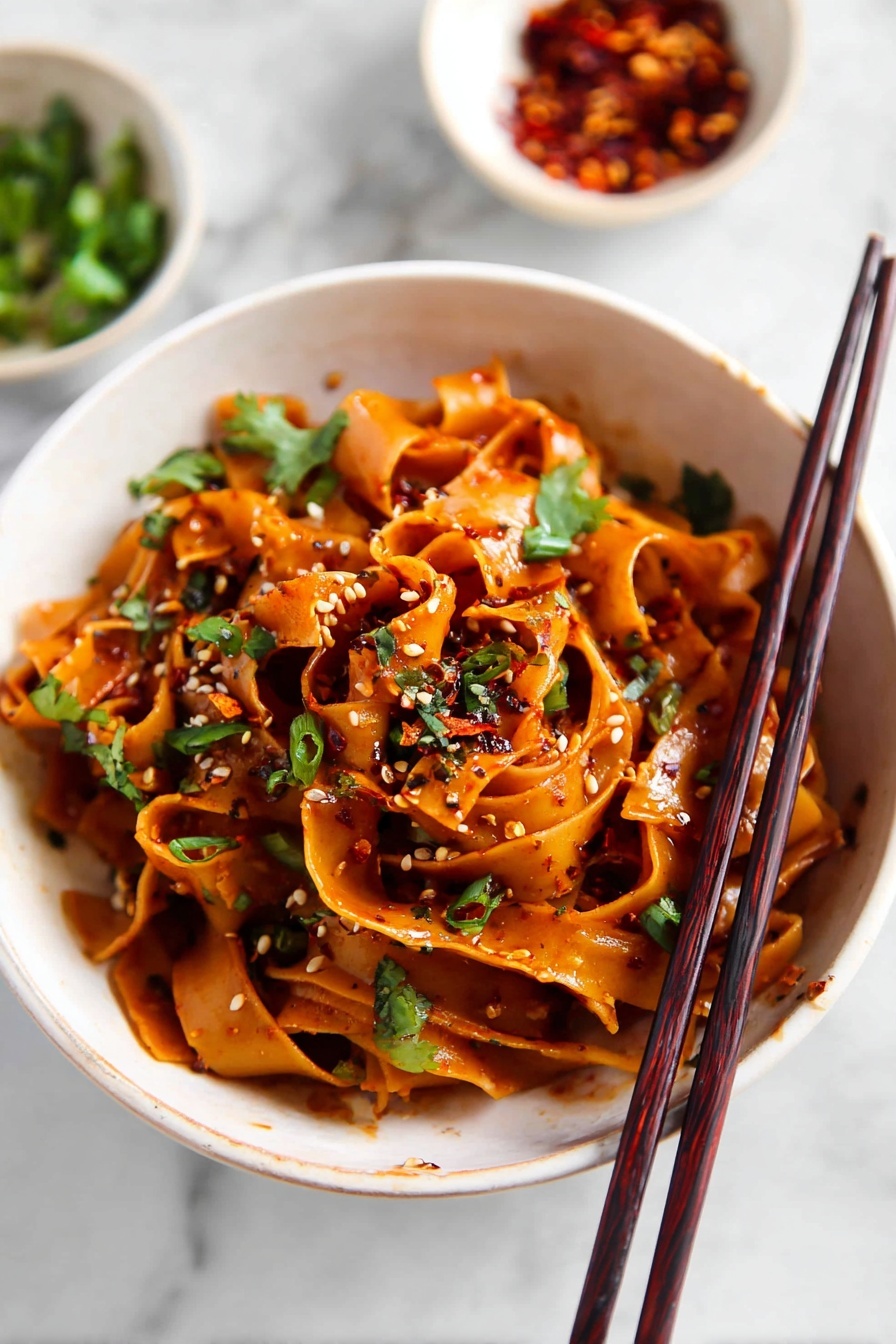 Spicy Chili Garlic Noodles, spicy Asian noodles, quick chili garlic pasta, spicy noodle stir-fry, flavorful chili garlic dish - The image shows a white pot filled with four layers of wide, flat noodles cooked in a dark brown sauce, giving the noodles a shiny and rich look. Scattered over the noodles are small pieces of green herbs and tiny bits of red chili pepper, adding a touch of color and texture. The noodles are swirled and mixed together with some areas appearing thicker and some thinner, showing a soft and smooth texture. The pot sits on a white marbled surface with a pair of dark brown chopsticks resting beside it. Nearby, there is a small white bowl filled with red chili flakes. Photo taken with an iphone --ar 2:3 --v 7