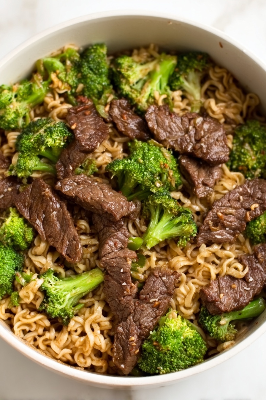 Beef Broccoli Ramen Stir Fry, quick beef broccoli stir fry, easy ramen noodle stir fry, healthy beef stir fry recipes, savory Asian stir fry - A white bowl filled with a noodle dish topped with several pieces of dark brown cooked meat arranged evenly across the surface, mixed with bright green broccoli florets scattered throughout. The noodles underneath are light brown and slightly wavy, filling the entire bowl, with the meat and broccoli sitting on top. The glossy texture of the meat contrasts with the softer noodles and the fresh look of the broccoli, all placed on a white marbled surface. Photo taken with an iphone --ar 2:3 --v 7