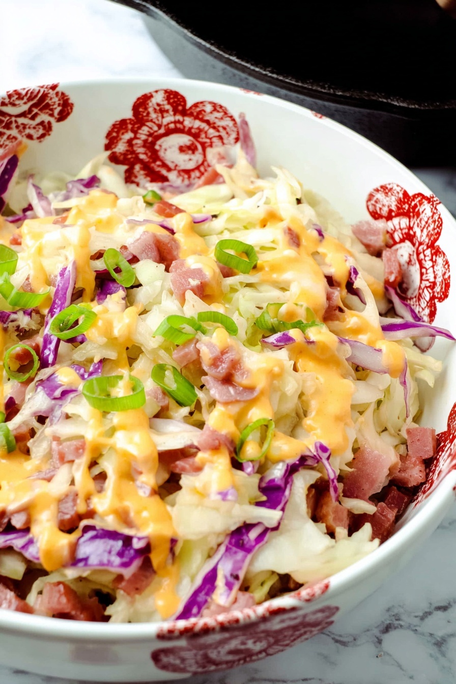 Keto Reuben Bowl, Reuben Bowl, Low-Carb Reuben, Keto Sandwich Alternative, Keto Dinner Ideas - The dish is shown in a black cast iron skillet filled with layers of shredded white and purple cabbage, small pieces of thinly sliced reddish meat, melted creamy white and orange cheeses drizzled on top, and sprinkled with bright green chopped onions. The cabbage forms the base with soft, thin textures, scattered evenly across the skillet. The meat pieces are scattered between the cabbage layers, adding a touch of reddish brown color. The cheese layers blend smoothly over the top with thick drips of orange sauce and melted white cheese covering the surface. Bright green onion pieces are spread on top in small round slices for a fresh look. The skillet sits on a white marbled surface with a white cloth visible in the background. photo taken with an iphone --ar 2:3 --v 7