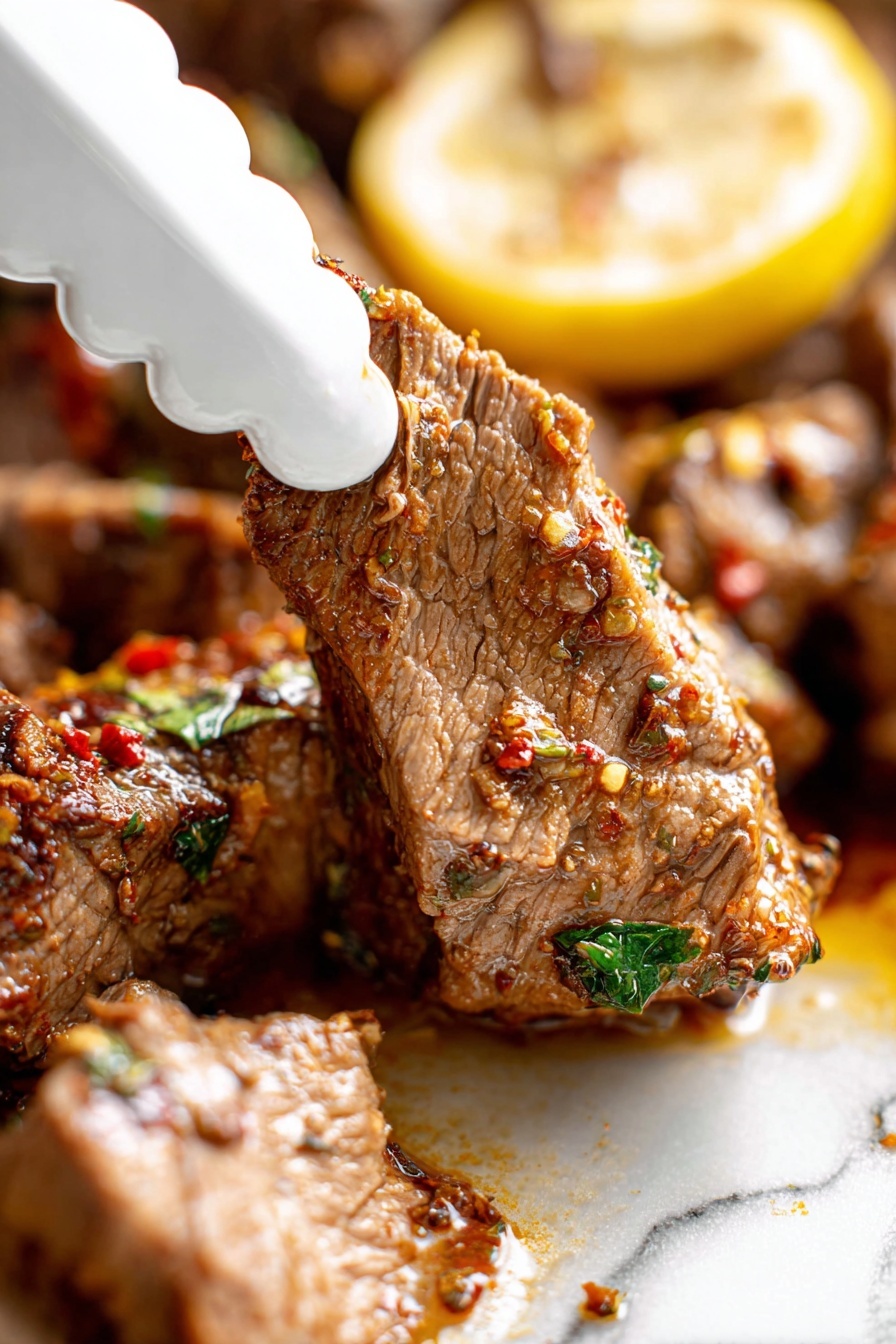 Slow Roasted Lamb Shoulder with Mint Sauce, Lamb shoulder recipe, Roasted lamb dinner, Mint sauce for lamb, Easy lamb roast - A close-up view of a piece of cooked meat being picked up by a white scalloped-edge tong, showing its tender texture with visible fibers and seasoning bits in red and green. The meat is brown with a moist surface, sitting next to a larger piece with the same texture, all on a white marbled surface. Behind the meat, there is a yellow lemon slice with some herbs on top, adding a pop of color. The scene is bright and focused on the meat’s juicy and spiced detail, photo taken with an iphone --ar 2:3 --v 7