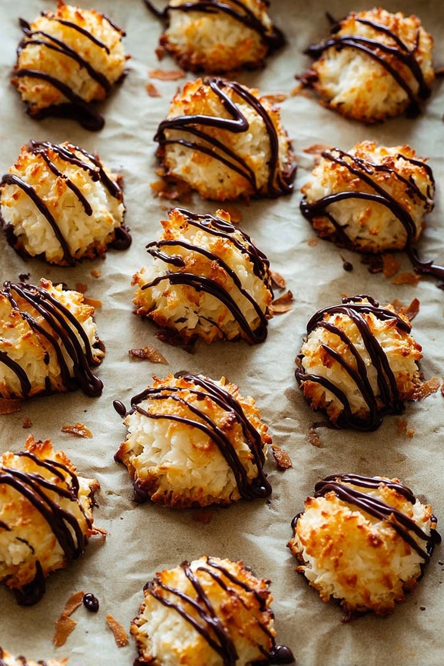 Coconut Macaroons with Chocolate Drizzle, coconut macaroon recipes, easy coconut macaroons, chocolate drizzle desserts, homemade coconut treats - The image shows many small, round coconut macaroons with a golden-brown, slightly crispy texture on the outside and white inside. Each macaroon is topped with thin, shiny dark chocolate drizzle in irregular lines, adding a rich contrast in color and glossy texture. These treats are placed on a baking sheet lined with parchment paper that has a light brown color, and some small browned coconut flakes are scattered around. The background is a white marbled texture. photo taken with an iphone --ar 2:3 --v 7