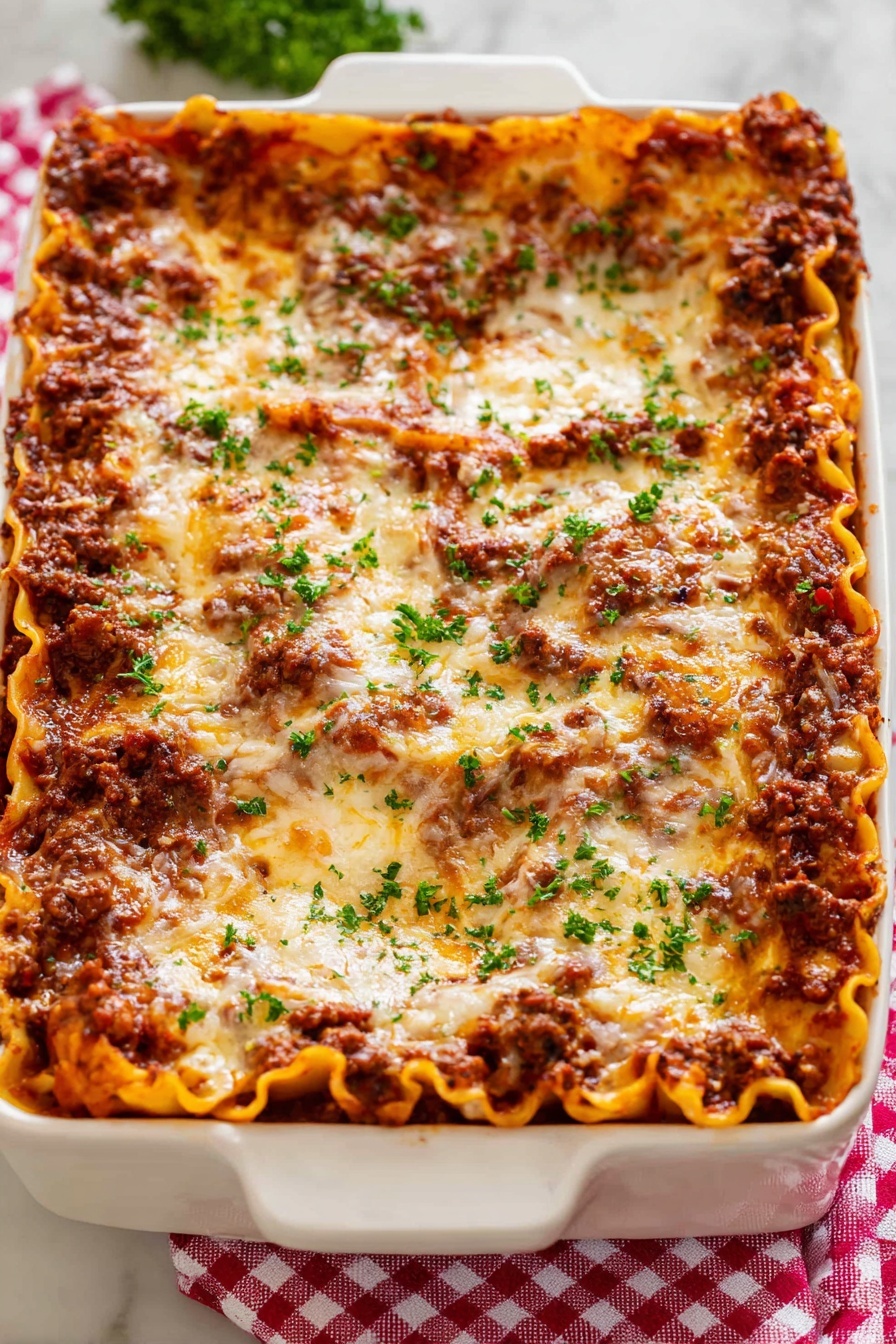 Homestyle Ground Beef Lasagna, easy ground beef lasagna, hearty beef lasagna recipe, homemade lasagna with meat sauce, comforting classic lasagna - A white rectangular baking dish holds a thick lasagna with about five layers visible; the bottom layer is flat orange pasta sheets, followed by a rich dark brown meat sauce, then another layer of pasta, meat sauce, and a top layer covered in melted golden cheese with brown spots. Small bits of fresh green parsley are sprinkled evenly on top, adding a fresh touch. The dish sits on a red and white checkered cloth over a white marbled surface. photo taken with an iphone --ar 2:3 --v 7