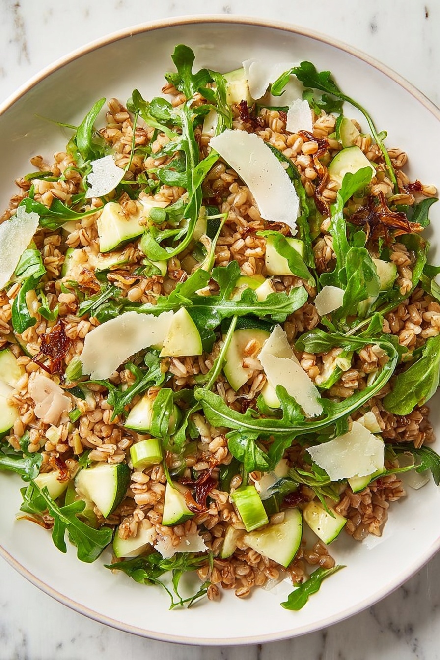 Healthy Farro Salad with Apple and Arugula, nutritious farro salad, fresh apple arugula salad, healthy grain salads, easy healthy salad recipes - A clear glass bowl holds a mixed salad with three main layers: a bottom layer of cooked brown grains, a middle layer of bright green arugula leaves with thin stems, and a top layer scattered with thin white cheese shavings and small green apple pieces. The grains look slightly shiny, and the arugula adds a fresh, leafy texture. The bowl sits on a white marbled surface with two empty white bowls in the background. Photo taken with an iphone --ar 2:3 --v 7