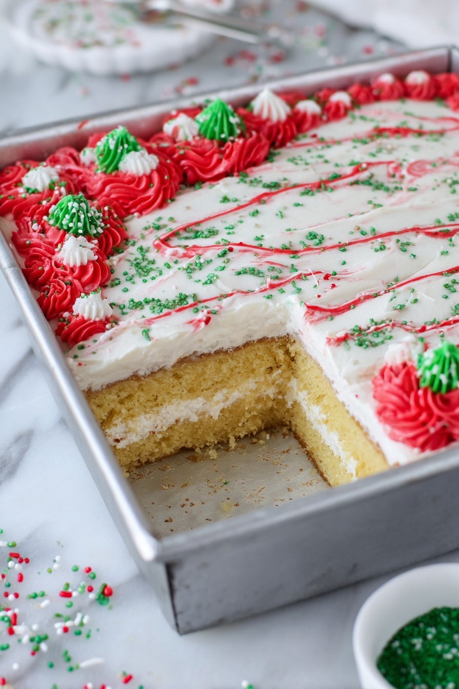 Christmas Tree Sheet Cake with White Chocolate Buttercream, holiday Christmas cake, festive birthday cake, easy Christmas dessert, decorating Christmas cake - The image shows a square cake in a silver metal pan with a piece taken out from one corner, revealing two layers of golden-yellow cake separated by a thick white cream layer. The top layer of the cake is smooth and covered with white frosting, decorated with thin red lines curving across the surface, green sugar sprinkles scattered evenly, and clusters of red frosting rosettes at the edges with additional green and white sprinkle pieces on top. The pan is placed on a white marbled surface with a small white bowl containing green sugar nearby and some scattered red, green, and white sprinkles around. photo taken with an iphone --ar 2:3 --v 7