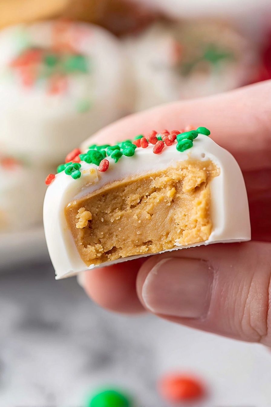 Homemade Peanut Butter Cups with Chocolate, easy peanut butter cup recipe, homemade candy, chocolate peanut butter treats, no-bake peanut butter cups - A close-up view shows a piece of candy held by a person's fingers with the focus on the candy's interior layers. The candy has two layers: the thick bottom layer is soft and light brown, with a crumbly texture like peanut butter, while the top layer is smooth, white, and looks like a frosting coating with green and red small round sprinkles on top. The background shows blurred white marbled texture and more colorful candies in the distance, out of focus. Photo taken with an iphone --ar 2:3 --v 7