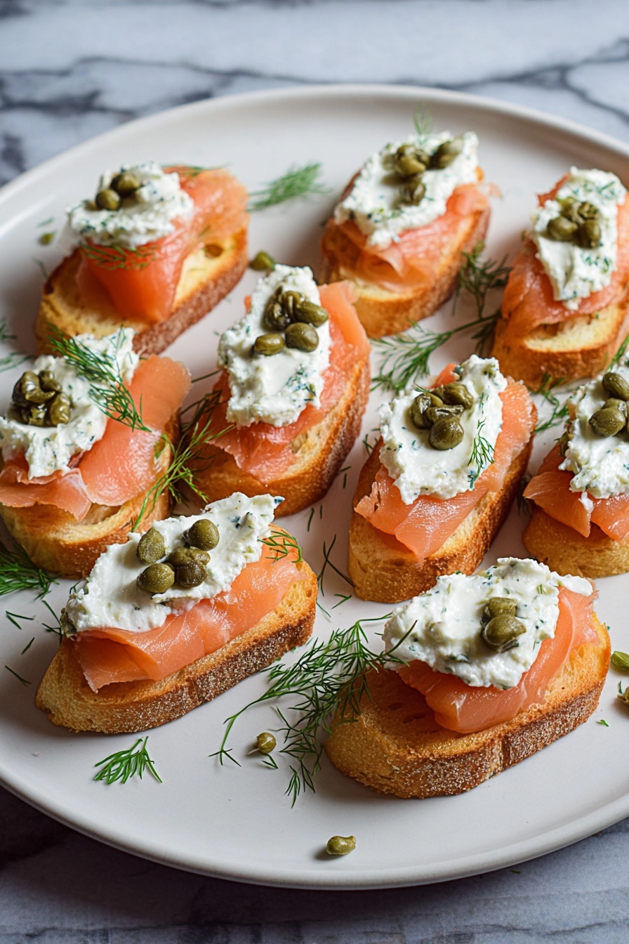 Smoked Salmon Crostini, smoked salmon appetizer, easy smoked salmon recipes, fancy brunch ideas, appetizer with smoked salmon - The image shows a white plate with several small toasted bread slices arranged in rows. Each slice is topped with three layers: the bottom layer is pinkish-orange smoked salmon with a smooth texture, the middle layer is a dollop of white creamy spread mixed with herbs, and the top layer features a few small green capers and a small sprig of fresh green dill. The plate sits on a white marbled surface with some scattered dill and capers around the edges. photo taken with an iphone --ar 2:3 --v 7