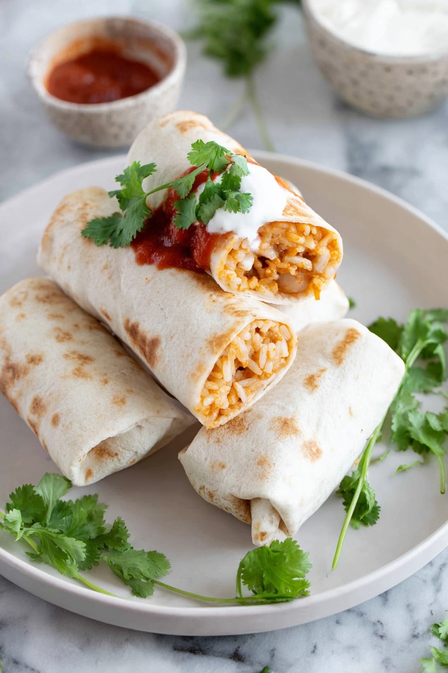 Cheesy Bean and Rice Burritos, cheesy bean burritos, easy burrito recipes, quick Mexican-inspired meals, savory bean and rice wraps - Two soft white tortillas are rolled and placed on a white plate, one whole and one cut in half showing a mix of orange-brown rice and beans inside. The cut burrito is stacked on top of the whole one. A dollop of white sour cream and red salsa sauce with some fresh green cilantro leaves are on top of the burritos. Extra cilantro leaves are scattered on the plate around the burritos. In the background, there is a small bowl of white sour cream on the white marbled surface. The photo is taken with an iphone --ar 2:3 --v 7