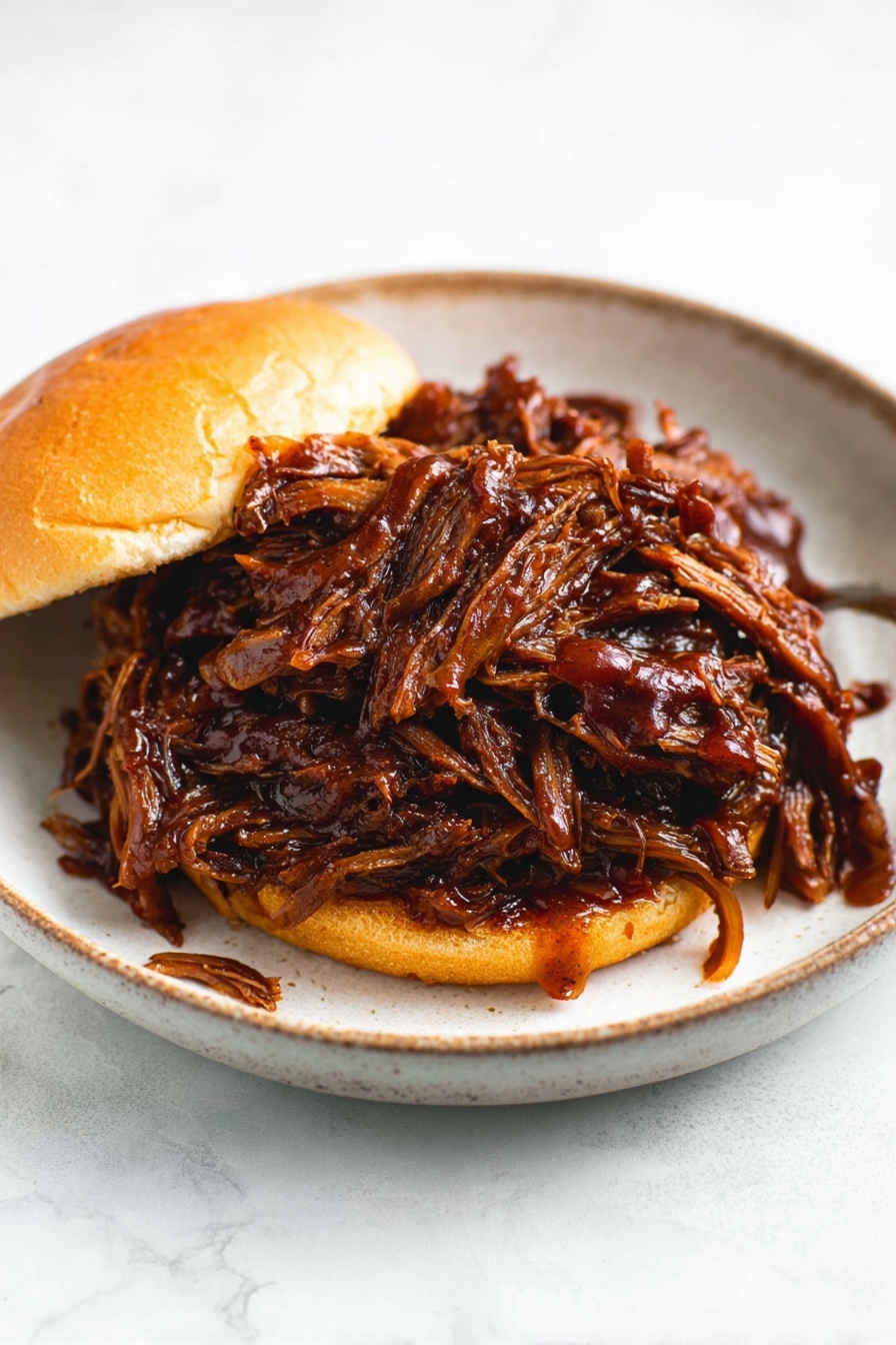 Slow Cooker Honey BBQ Beef Brisket, tender beef brisket, BBQ beef recipes, slow cooker beef dinner, easy BBQ brisket - A sandwich on a soft, shiny light brown bun with two layers: the bottom bun and the top bun. Between them is a large pile of dark brown shredded meat covered in thick, shiny barbecue sauce that drips slightly onto the white marbled surface and around the sandwich. The sandwich sits on a white plate with a soft black color and a slightly glossy texture, and the background is a white marbled texture. photo taken with an iphone --ar 2:3 --v 7