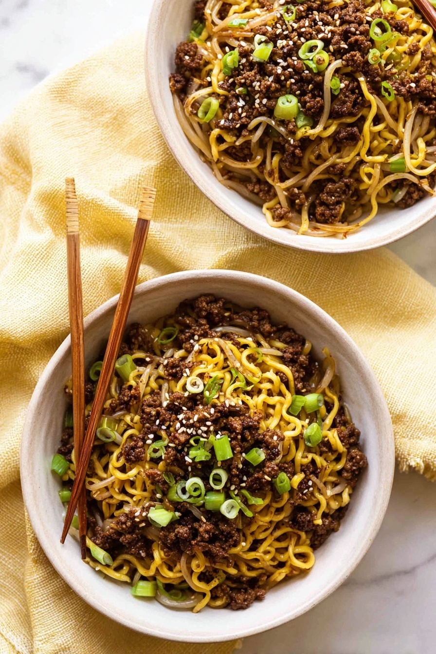 Quick Asian Beef Ramen, Asian Beef Ramen recipe, Fast ramen with beef, Easy Asian noodle bowl, Savory beef ramen - Two white bowls are filled with cooked yellow noodles mixed with dark brown ground meat and light brown bean sprouts. The noodles are topped with small, bright green chopped spring onions and a few white sesame seeds sprinkled on top. One bowl has light brown wooden chopsticks resting on its edge. The bowls sit on a soft, light yellow cloth, placed on a white marbled surface. photo taken with an iphone --ar 2:3 --v 7