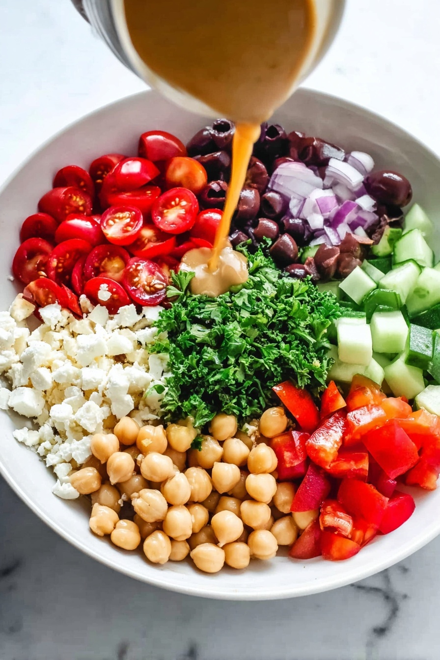 Easy Mediterranean Chickpea Salad, Mediterranean Chickpea Salad, Healthy Chickpea Salad, Quick Vegetarian Salad, Easy Summer Salad - A white bowl holds seven distinct layers arranged in a circle on a white marbled surface. Starting from the left, there are bright red, halved cherry tomatoes, next to a pile of small, crumbly white cheese pieces. Moving clockwise, a section of dark purple sliced olives sits beside chopped fresh green parsley in the center. Next to the parsley are cubes of light green cucumber and bright red diced bell peppers. Opposite the tomatoes, tan chickpeas form a rounded cluster. A woman's hand pours a smooth, light brown dressing from a jar over the ingredients, adding a glossy shine to the mix. photo taken with an iphone --ar 2:3 --v 7