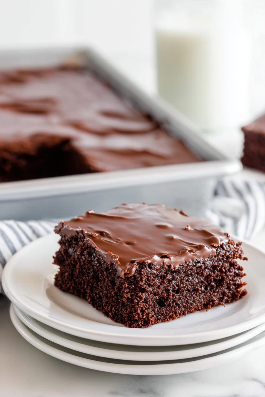 Texas Sheet Cake with Rich Cocoa Frosting, best Texas sheet cake, simple chocolate sheet cake recipe, easy chocolate cake for parties, moist chocolate sheet cake - A close-up of a chocolate sheet cake with two layers, the bottom layer is a soft, dark brown cake with a slightly crumbly texture, and the top layer is a shiny, smooth chocolate glaze covering the entire surface. The cake is cut into squares, and one piece is missing, revealing the inside texture. The cake is inside a white baking pan set on a white marbled surface, with parts of a woman's hand visible holding the pan. In the background, there is a soft blur of stacked white plates. photo taken with an iphone --ar 2:3 --v 7