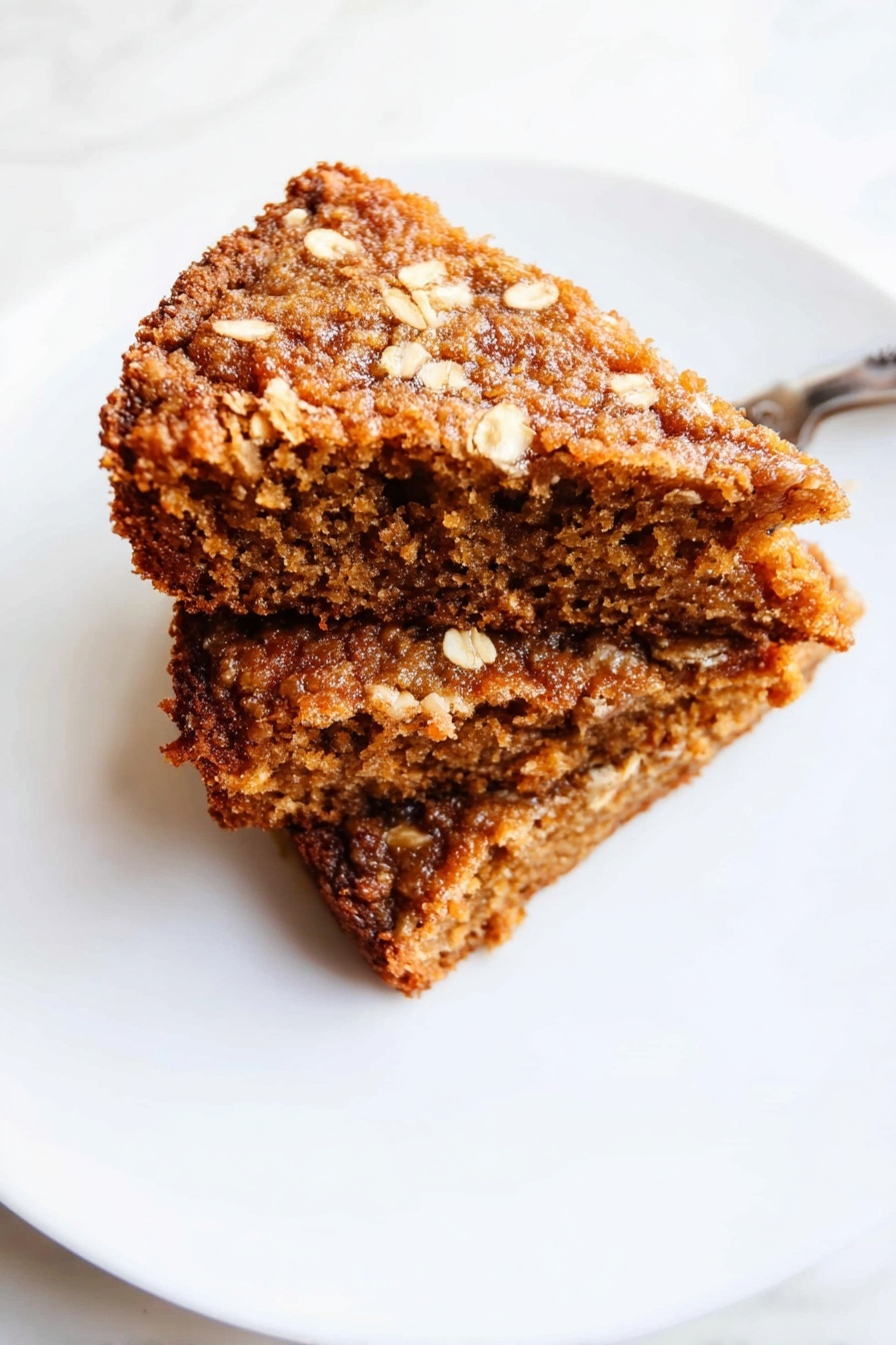 Healthy Apple Oatmeal Cake, healthy apple oatmeal cake, wholesome apple cake, gluten-free oatmeal dessert, nutritious fruit breakfast - The image shows three brown, textured snack bars stacked on top of each other on a white marbled surface. Each bar looks soft and moist inside with a rough, slightly crispy outer layer. The bars have an uneven, crumbly texture with small visible bits that suggest oats or nuts, and their edges appear slightly jagged. The lighting highlights the bars’ warm color and their dense, chewy appearance. Photo taken with an iphone --ar 2:3 --v 7