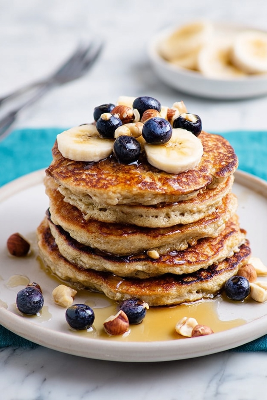 Healthy Banana Oat Pancakes, healthy breakfast recipes, easy banana pancakes, nutritious pancake ideas, quick wholesome breakfast - A stack of four golden-brown pancakes sits in the center of a white plate, each pancake textured with small bubbles and crispy edges. On top, there are three banana slices with a shiny drizzle of syrup pooling slightly and small pieces of chopped nuts sprinkled over them. Around the plate, scattered banana slices and nut pieces add a casual touch, all set against a white marbled background. photo taken with an iphone --ar 2:3 --v 7