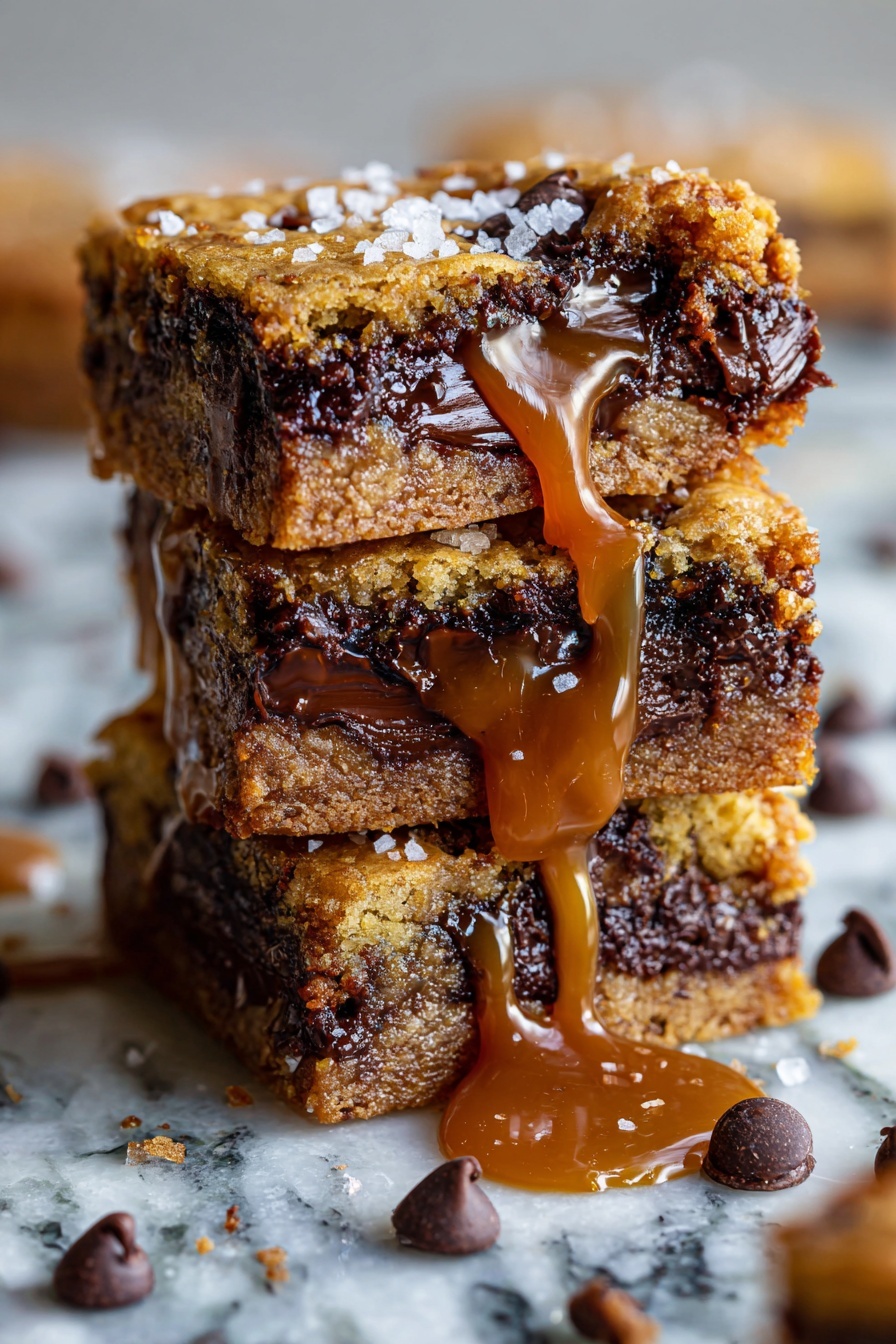 Salted Caramel Chocolate Chip Oat Bars, Easy caramel oat bars, Chewy chocolate chip oat bars, No-bake dessert bars, Salted caramel snack bars - This close-up image shows a thick bar dessert with three main layers. The bottom layer is a crumbly, light brown cookie base with a rough texture. The middle layer is dark, melted chocolate that looks soft and rich. The top layer is a smooth, shiny caramel that slightly drips down the sides. Small coarse salt flakes are scattered on the caramel. The dessert pieces are placed on a white marbled surface, with a few scattered crumbs around. Photo taken with an iphone --ar 2:3 --v 7
