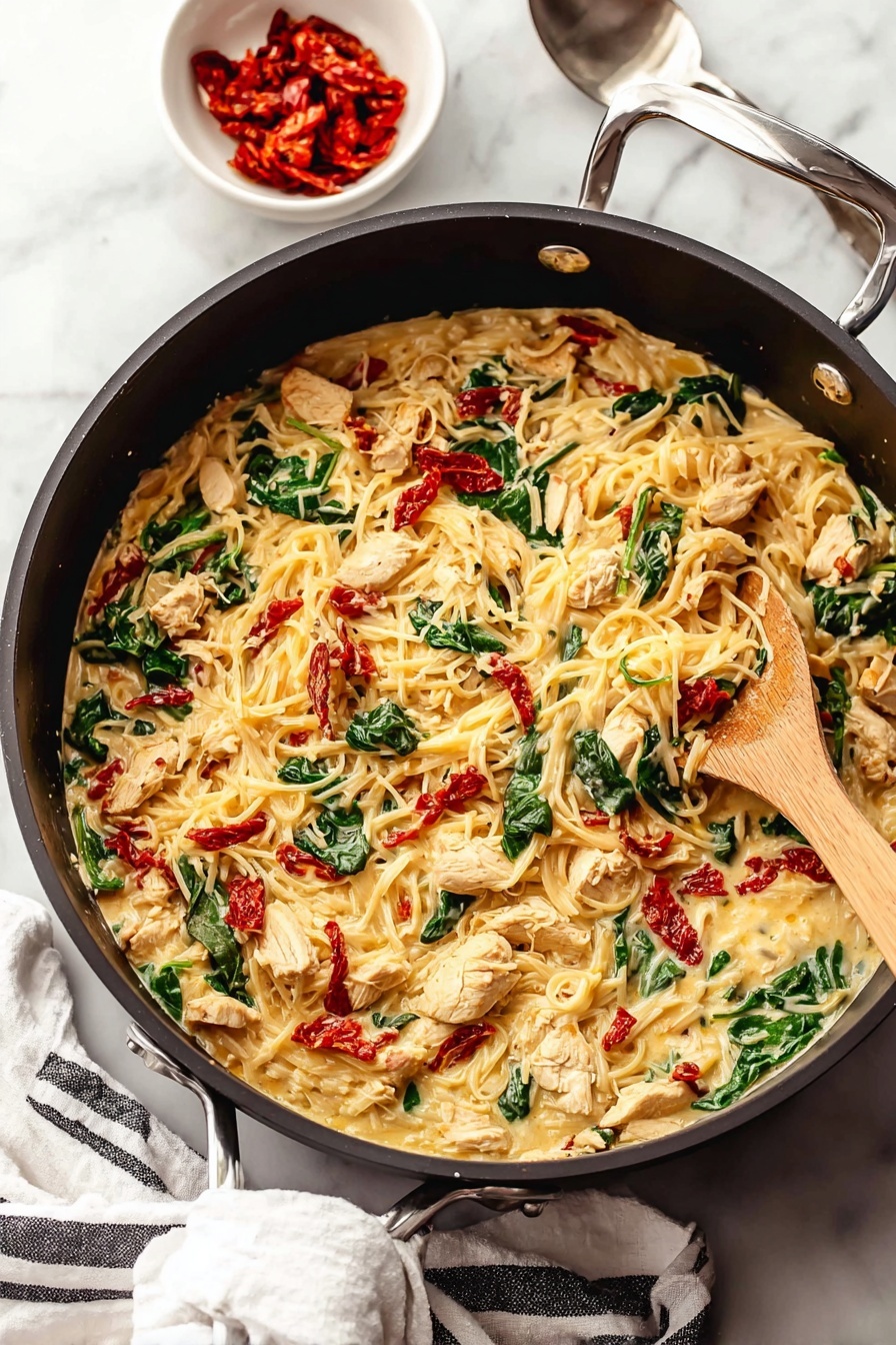 Tuscan Chicken with Spaghetti Squash, healthy Tuscan chicken recipes, low-carb chicken dinner, Italian chicken with spaghetti squash, easy Tuscan chicken meal - A large black pan filled with a creamy pasta dish that has three main layers: the creamy sauce with melted cheese forms the base, mixed through with tender pieces of seasoned light brown chicken, bright green spinach leaves, and small chunks of red sun-dried tomatoes scattered evenly throughout. A light wooden spoon is stirring the mixture from the right side of the pan. Near the pan, on a white marbled surface, sits a small white bowl filled with more red sun-dried tomatoes and a silver spoon nearby. A white cloth with black stripes is placed casually under the pan handle. Photo taken with an iphone --ar 2:3 --v 7
