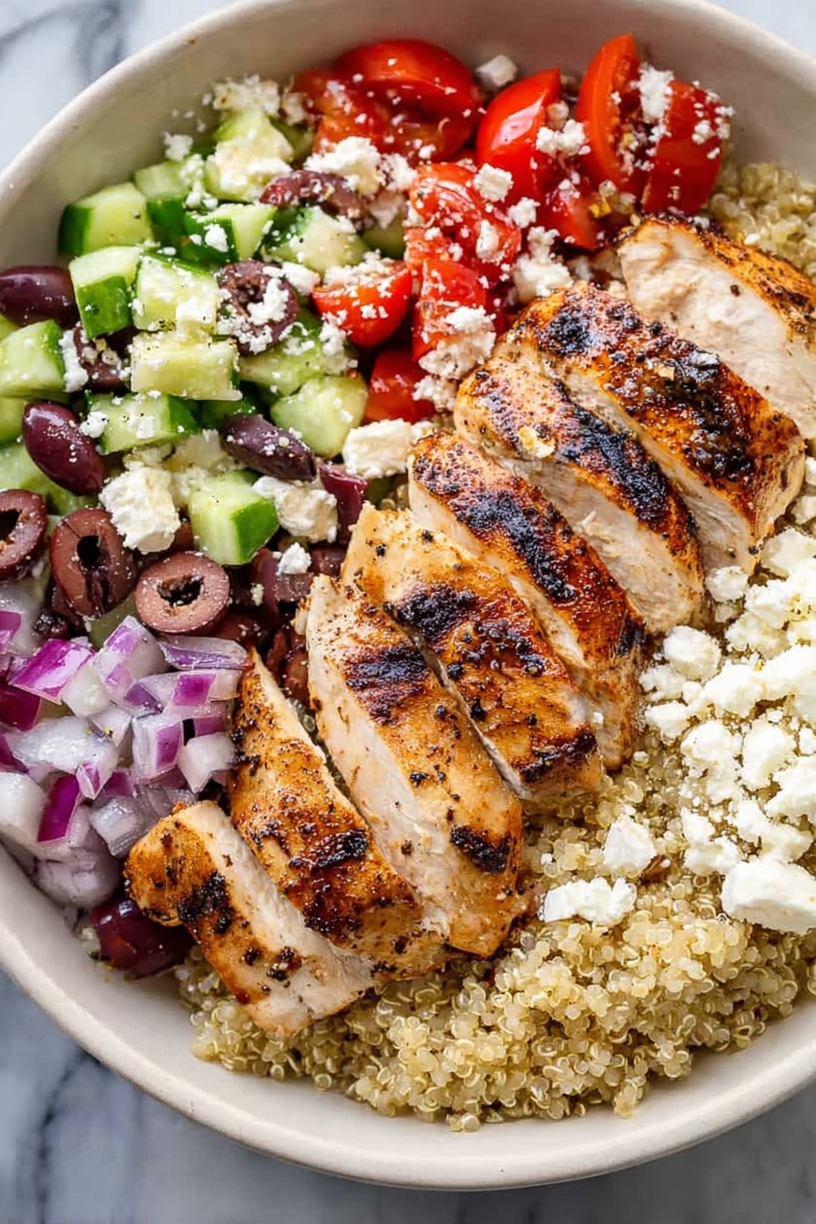 Greek Chicken Quinoa Bowls, Greek Chicken Bowl, Mediterranean Chicken Quinoa, Healthy Greek Bowls, Easy Quinoa Bowls - A white bowl holds a colorful layered dish on a white marbled surface. The bottom layer is light beige quinoa. On top of this, sliced grilled chicken with visible char marks sits to one side. To the right of the chicken is a mix of chopped red tomatoes and small pieces of red onion. Below the tomato mix is chopped green cucumber with some purple olives scattered throughout. White crumbled cheese is sprinkled over the top of the tomatoes, cucumbers, and olives. The colors contrast well, showing fresh and healthy ingredients. Photo taken with an iphone --ar 2:3 --v 7