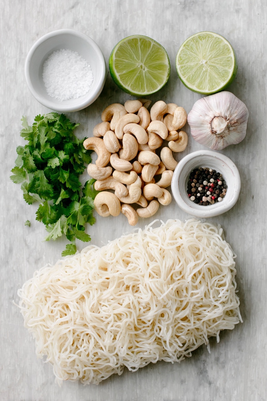 Vegan Cilantro Lime Noodles, vegan noodle recipes, healthy vegan pasta, easy vegan dinner ideas, fresh plant-based meals - Flat lay of raw cashews in a small pile, a small handful of bright green cilantro sprigs, two whole uncracked garlic cloves, a whole fresh lime with one half cut to show the juicy interior and scattered lime zest, a small white ceramic bowl filled with clear water, a small white ceramic bowl containing coarse salt, a small white ceramic bowl with cracked black peppercorns, and a neat bundle of tofu shirataki spaghetti shaped noodles, all arranged in perfect symmetry on a clean white marble surface, soft natural light, photo taken with an iPhone, professional food photography style, fresh ingredients, white ceramic bowls, no bottles, no duplicates, no utensils, no packaging --ar 2:3 --v 7 --p m7354615311229779997