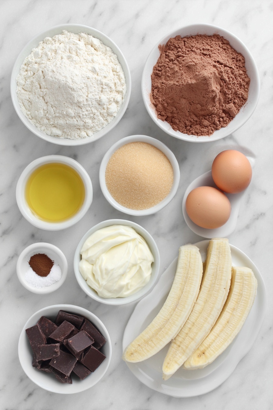 Chocolate Espresso Banana Bread, Banana Bread with Espresso and Chocolate, Moist Banana Bread Recipe, Easy Banana Bread with Coffee, Best Banana Nut Bread - Flat lay of a small mound of all purpose flour, a small mound of cocoa powder, a teaspoon of fine espresso powder, a teaspoon of kosher salt, a teaspoon of baking soda, a small white bowl of golden olive oil, a small white bowl filled with light brown granulated sugar and another small white bowl with white granulated sugar, two whole uncracked brown eggs with clean shells, a small white bowl of sour cream, a small plate with three ripe peeled bananas, a small white bowl with dark chocolate chips, another small white bowl with semi sweet chocolate chips, two long thin banana slices on a simple white ceramic plate arranged neatly beside the bowls, all ingredients arranged symmetrically and proportionally, placed on a clean white marble surface, soft natural light, photo taken with an iPhone, professional food photography style, fresh ingredients, white ceramic bowls, no bottles, no duplicates, no utensils, no packaging --ar 2:3 --v 7 --p m7354615311229779997