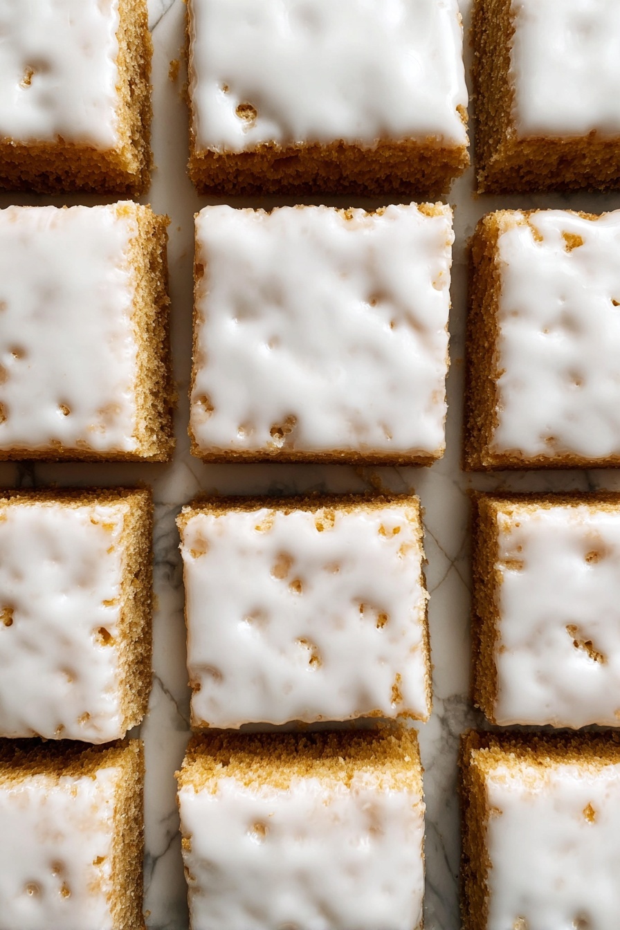 Iced Oatmeal Cookie Bars, oatmeal cookie bars, no-bake oatmeal bars, easy oatmeal cookie bars, chewy oatmeal bar recipe - The image shows nine square pieces of a light brown cake arranged in a 3x3 grid on a white marbled surface. Each piece is thick and topped with a smooth, glossy white icing that covers the entire top layer but is slightly uneven, with some small holes and cracks revealing the cake underneath. The edges between the squares are cleanly cut, showing the dense texture of the cake layers below the shiny icing. photo taken with an iphone --ar 2:3 --v 7